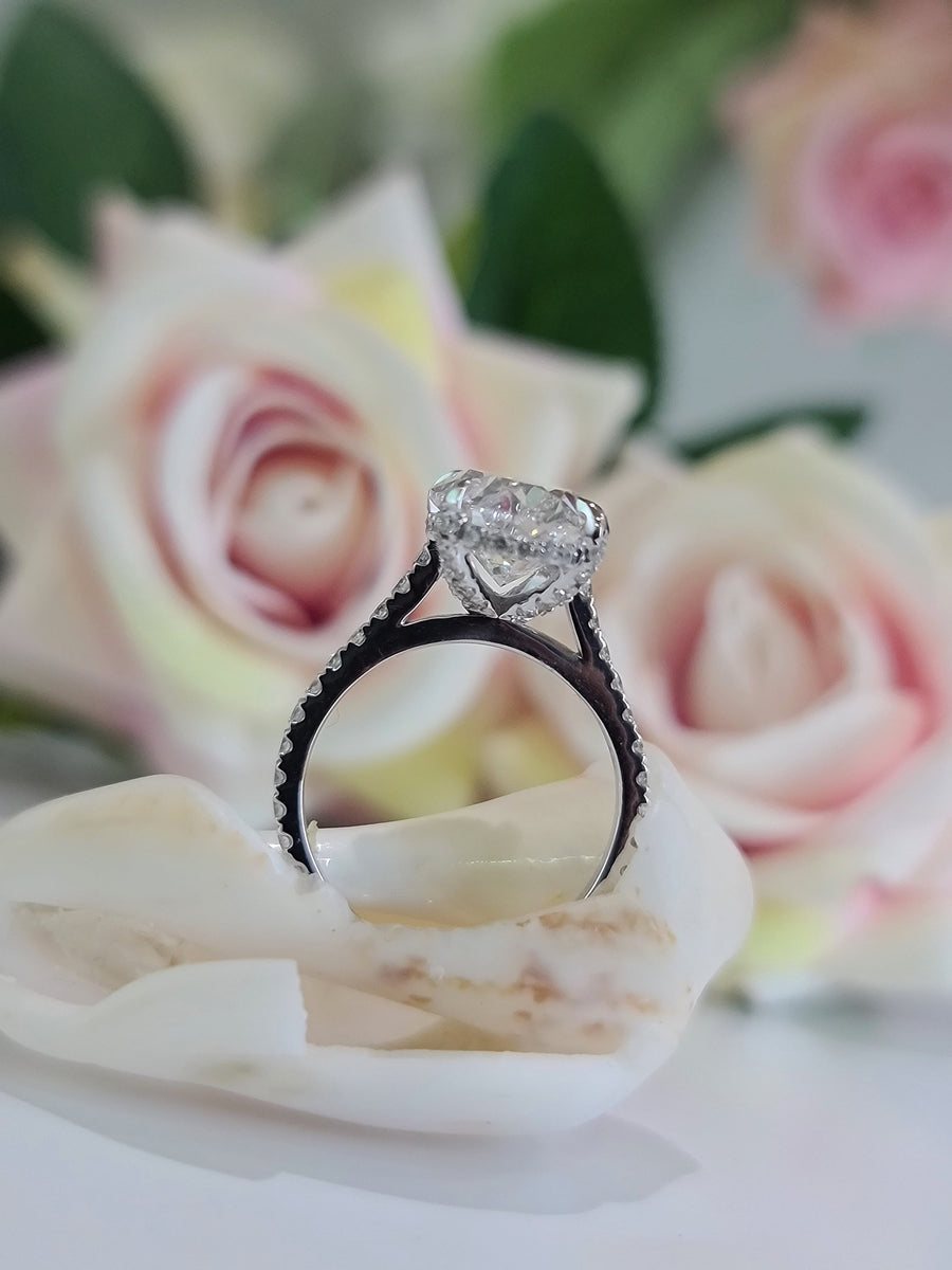 Oval cut lab grown diamond hidden halo engagement ring with delicate pavé accents set in polished gold band