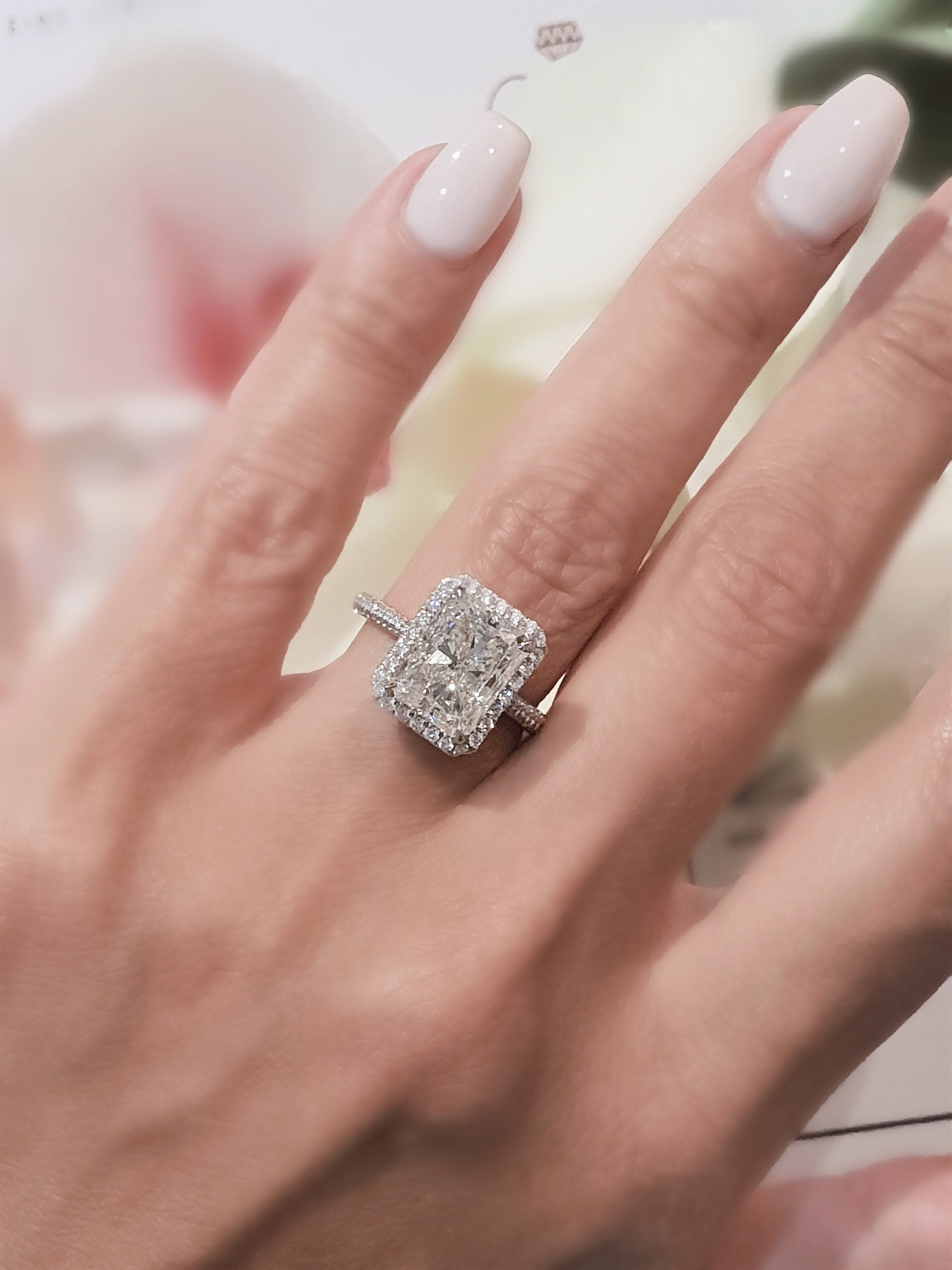 Radiant cut lab grown diamond halo engagement ring with center stone surrounded by pavé diamonds in polished gold setting