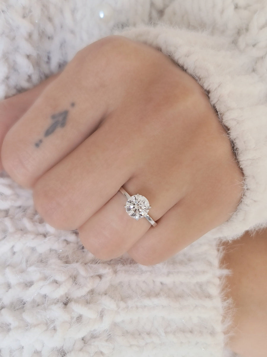 Round cut lab grown diamond solitaire engagement ring in classic prong setting with polished gold band