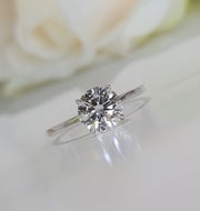 Round cut lab grown diamond solitaire engagement ring in classic prong setting with polished gold band